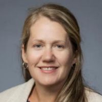 Portrait of a researcher smiling against a neutral background.