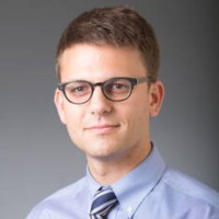 Portrait of a researcher in a dress shirt and tie.